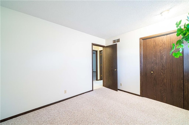 unfurnished bedroom featuring carpet flooring, a closet, and a textured ceiling