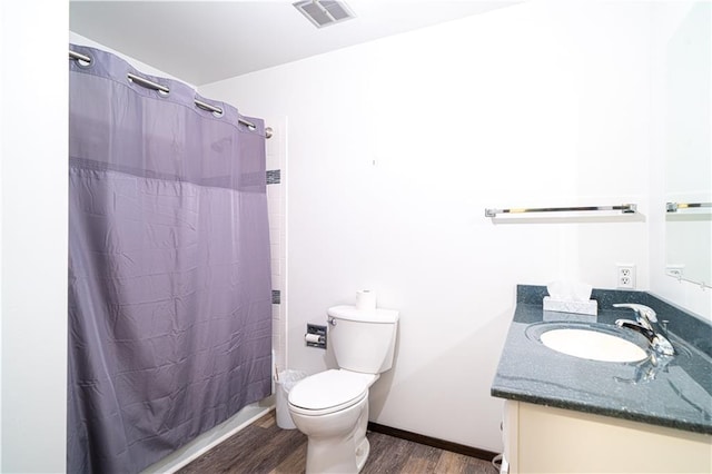 bathroom featuring walk in shower, vanity, wood-type flooring, and toilet