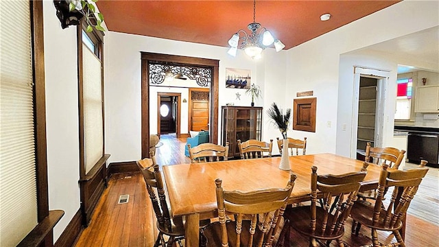 dining space featuring hardwood / wood-style floors and a notable chandelier