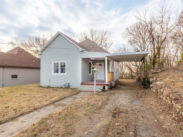 view of front of home with a front yard and a carport