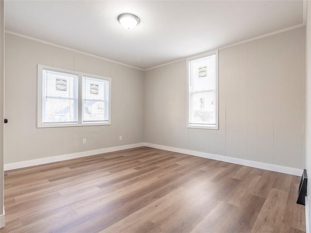 unfurnished room with crown molding, plenty of natural light, and light hardwood / wood-style floors