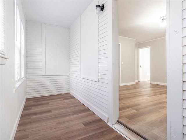 hall with wood-type flooring and crown molding