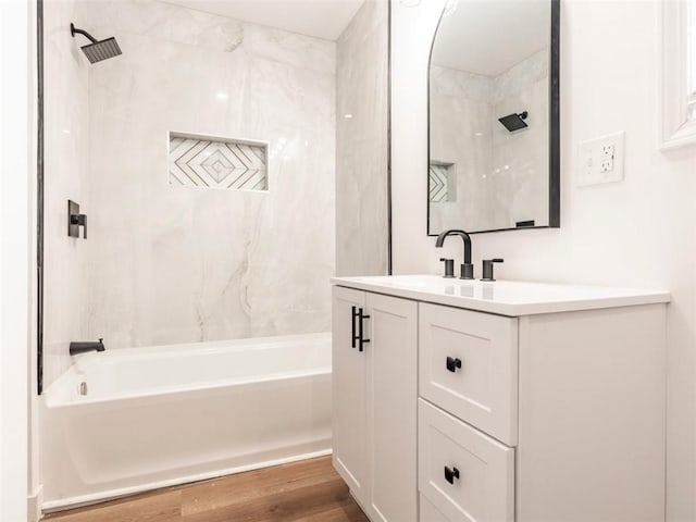 bathroom featuring hardwood / wood-style flooring, vanity, and tiled shower / bath