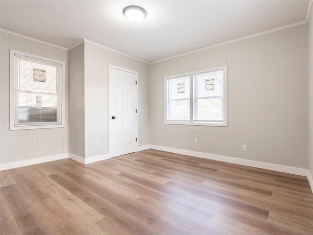 empty room with ornamental molding and light wood-type flooring