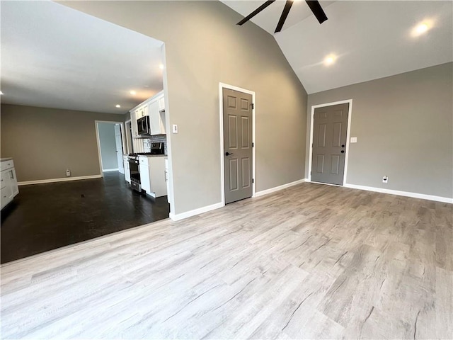 unfurnished living room featuring ceiling fan, light hardwood / wood-style floors, and vaulted ceiling