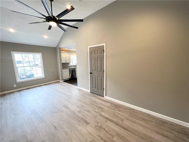 empty room featuring lofted ceiling, ceiling fan, and light wood-type flooring