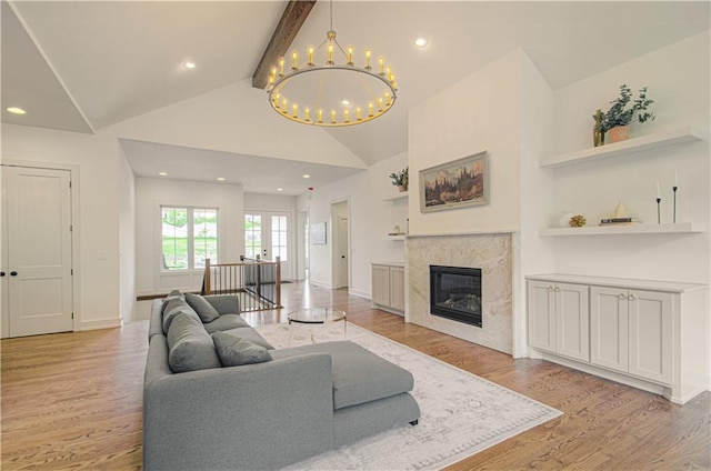 2150 NW Scenic View Dr, Riverside, MO 64150 - living area featuring light wood finished floors, a chandelier, beam ceiling, a fireplace, and high vaulted ceiling