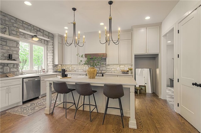 2150 NW Scenic View Dr, Riverside, MO 64150 - kitchen featuring decorative backsplash, stainless steel dishwasher, a kitchen bar, a center island, and a chandelier