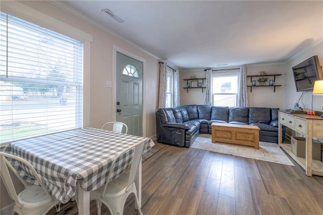 living room featuring hardwood / wood-style floors, a wealth of natural light, and ornamental molding