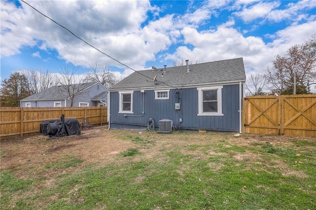 rear view of property featuring a lawn and cooling unit