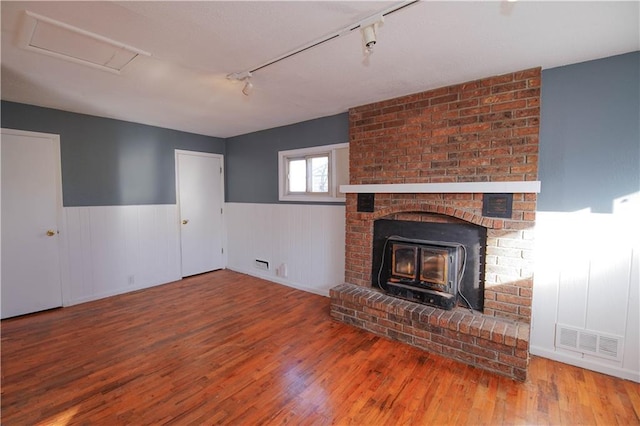 unfurnished living room featuring rail lighting and wood-type flooring