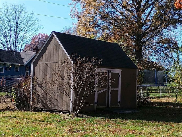 view of outdoor structure with a yard and a trampoline