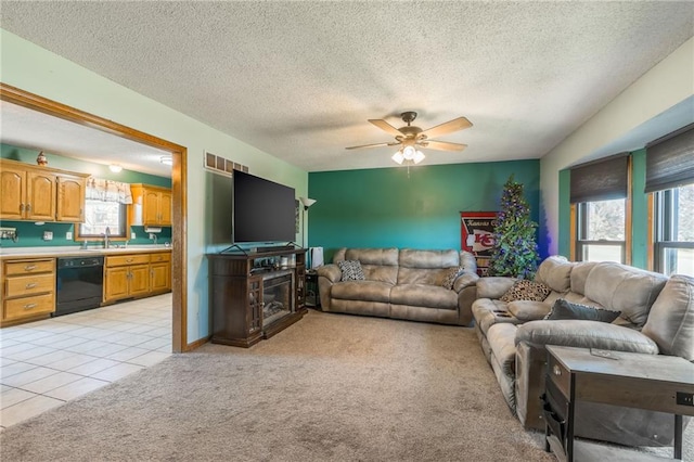 carpeted living room featuring ceiling fan, a healthy amount of sunlight, and a textured ceiling