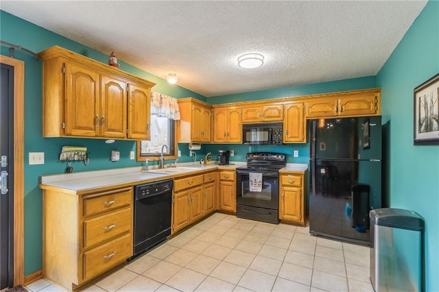 kitchen featuring black appliances, light tile patterned floors, sink, and a textured ceiling