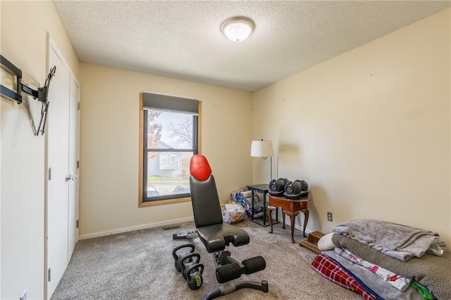 workout area with carpet and a textured ceiling