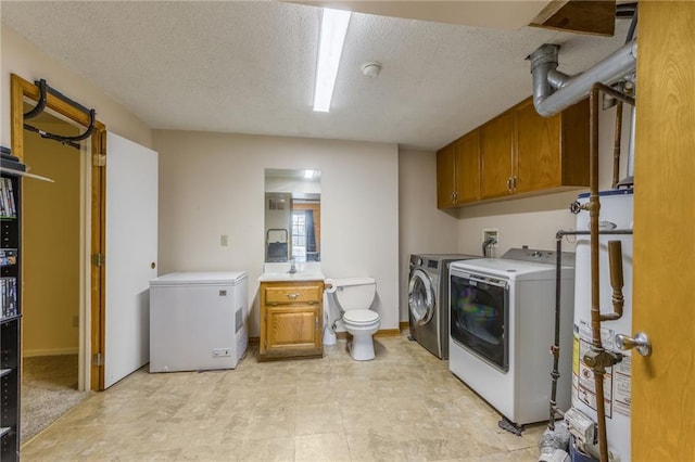 laundry area featuring a textured ceiling, washer and clothes dryer, and gas water heater