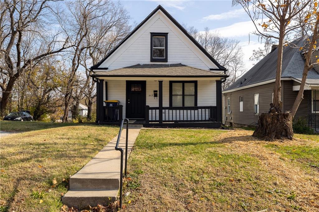 bungalow-style home featuring covered porch and a front lawn