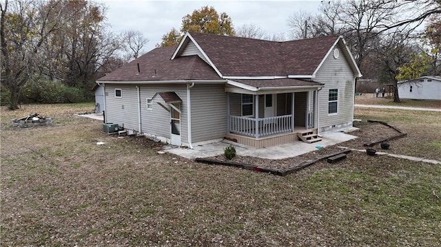 view of front of house featuring covered porch, central AC, and a front yard