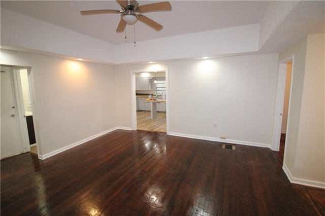 empty room with ceiling fan and dark wood-type flooring