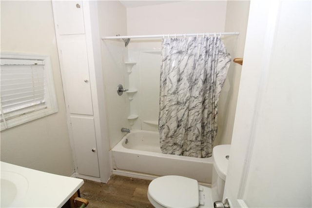 full bathroom featuring hardwood / wood-style floors, vanity, shower / tub combo, and toilet