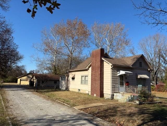 view of side of property featuring an outbuilding, a yard, and a garage