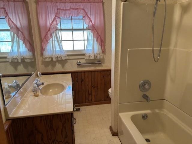 full bathroom with shower / bathing tub combination, plenty of natural light, toilet, and vanity