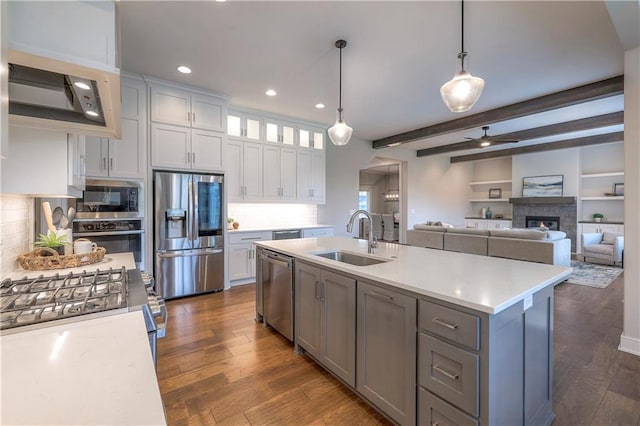 kitchen with appliances with stainless steel finishes, sink, beamed ceiling, dark hardwood / wood-style floors, and white cabinetry