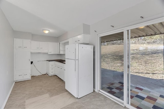 kitchen featuring white fridge and white cabinetry