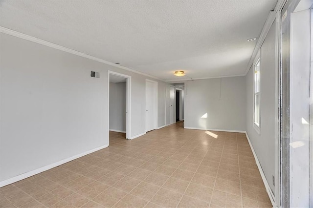 spare room featuring crown molding and a textured ceiling