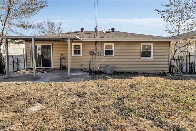 back of house with a patio area and a lawn