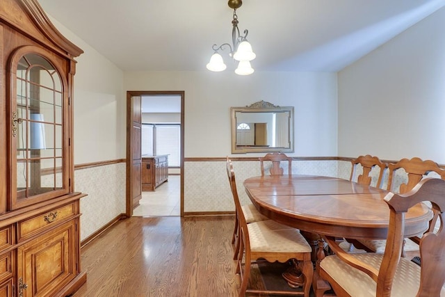 dining area featuring light hardwood / wood-style floors and an inviting chandelier