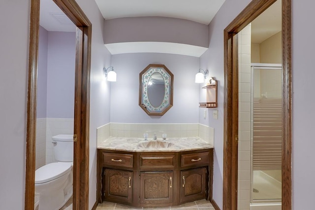 bathroom with tile patterned flooring, vanity, toilet, and walk in shower