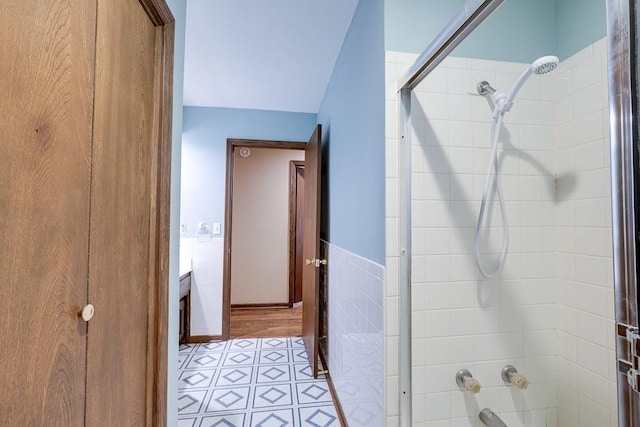 bathroom featuring tile patterned floors, vanity, tile walls, and tiled shower / bath