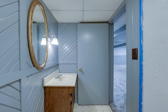 bathroom featuring vanity and wood walls