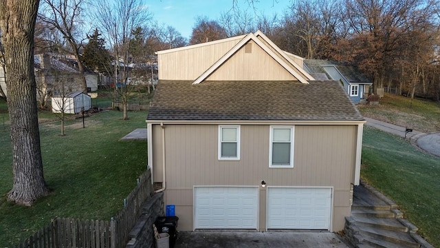 view of side of property featuring a garage and a lawn