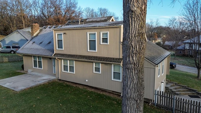 rear view of house featuring a yard and a patio