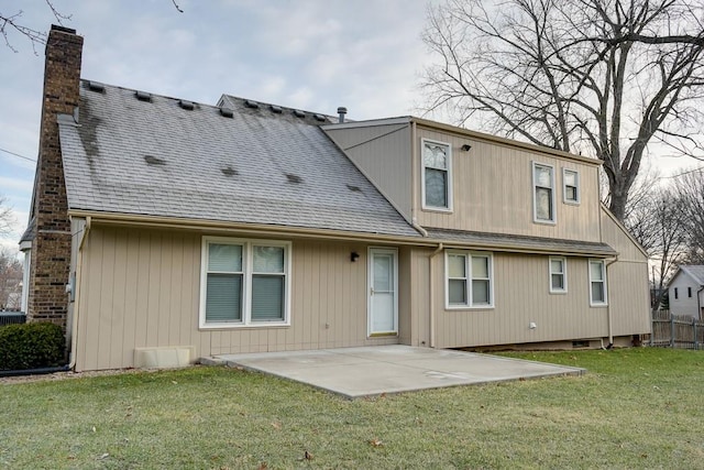 rear view of property featuring a lawn and a patio