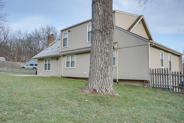 rear view of house featuring a lawn