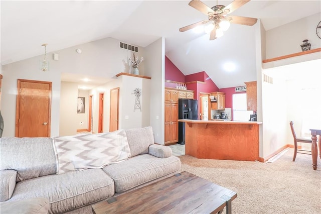 carpeted living room with ceiling fan and high vaulted ceiling