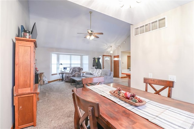 dining space featuring light carpet, ceiling fan, and high vaulted ceiling