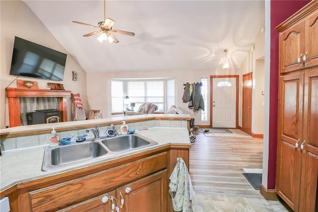 kitchen with ceiling fan, light hardwood / wood-style flooring, vaulted ceiling, and sink