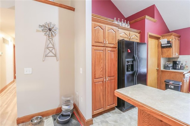 kitchen with black fridge and vaulted ceiling