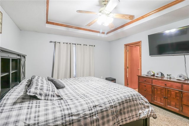 bedroom featuring carpet floors, a raised ceiling, and ceiling fan