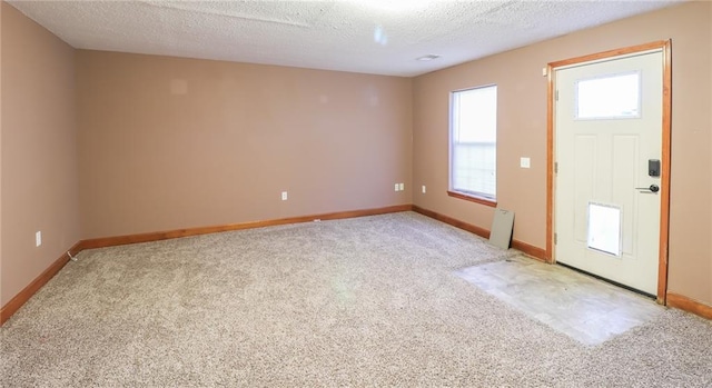 carpeted entryway featuring a textured ceiling