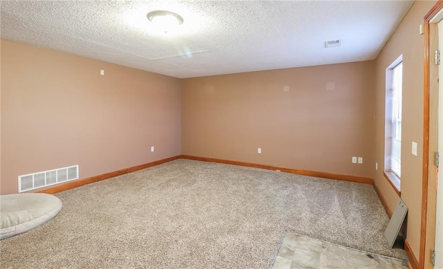 carpeted spare room with a textured ceiling