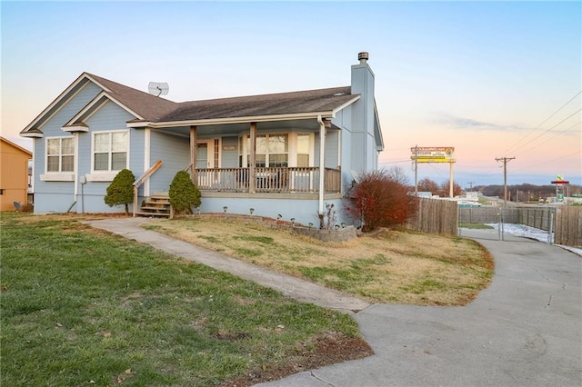 view of front facade with covered porch and a yard