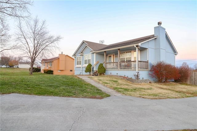 view of front of house featuring a lawn and covered porch