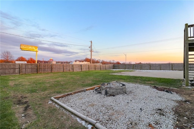 yard at dusk featuring an outdoor fire pit