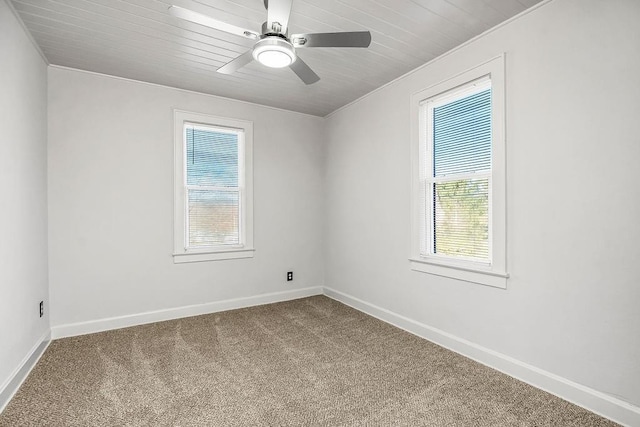 carpeted spare room with ceiling fan, wooden ceiling, and crown molding