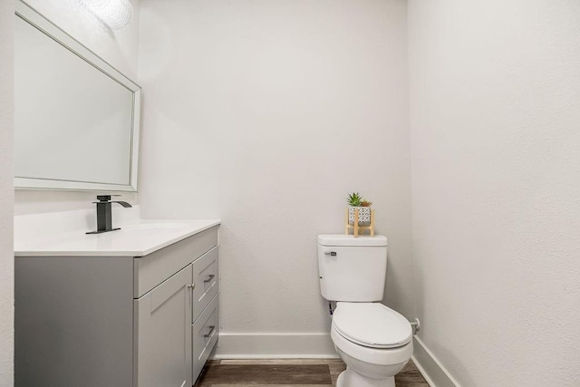 bathroom featuring hardwood / wood-style floors, vanity, and toilet